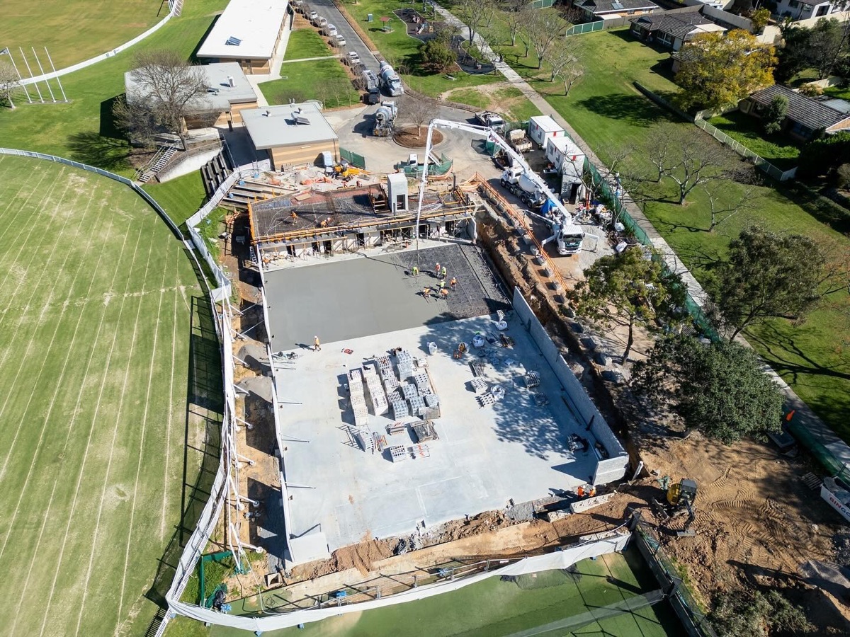 Aerial view of a concrete slab being poured on an active construction site