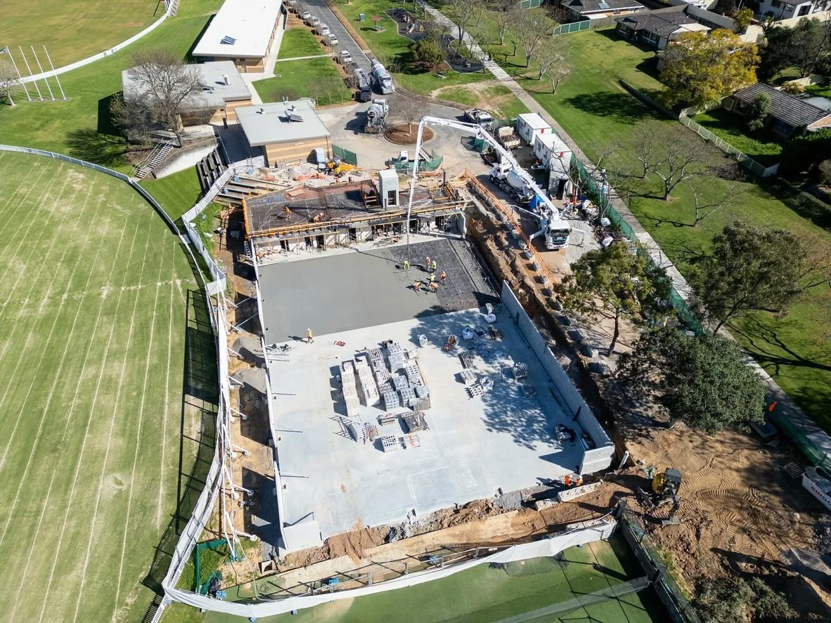 Aerial view of a concrete slab being poured on an active construction site