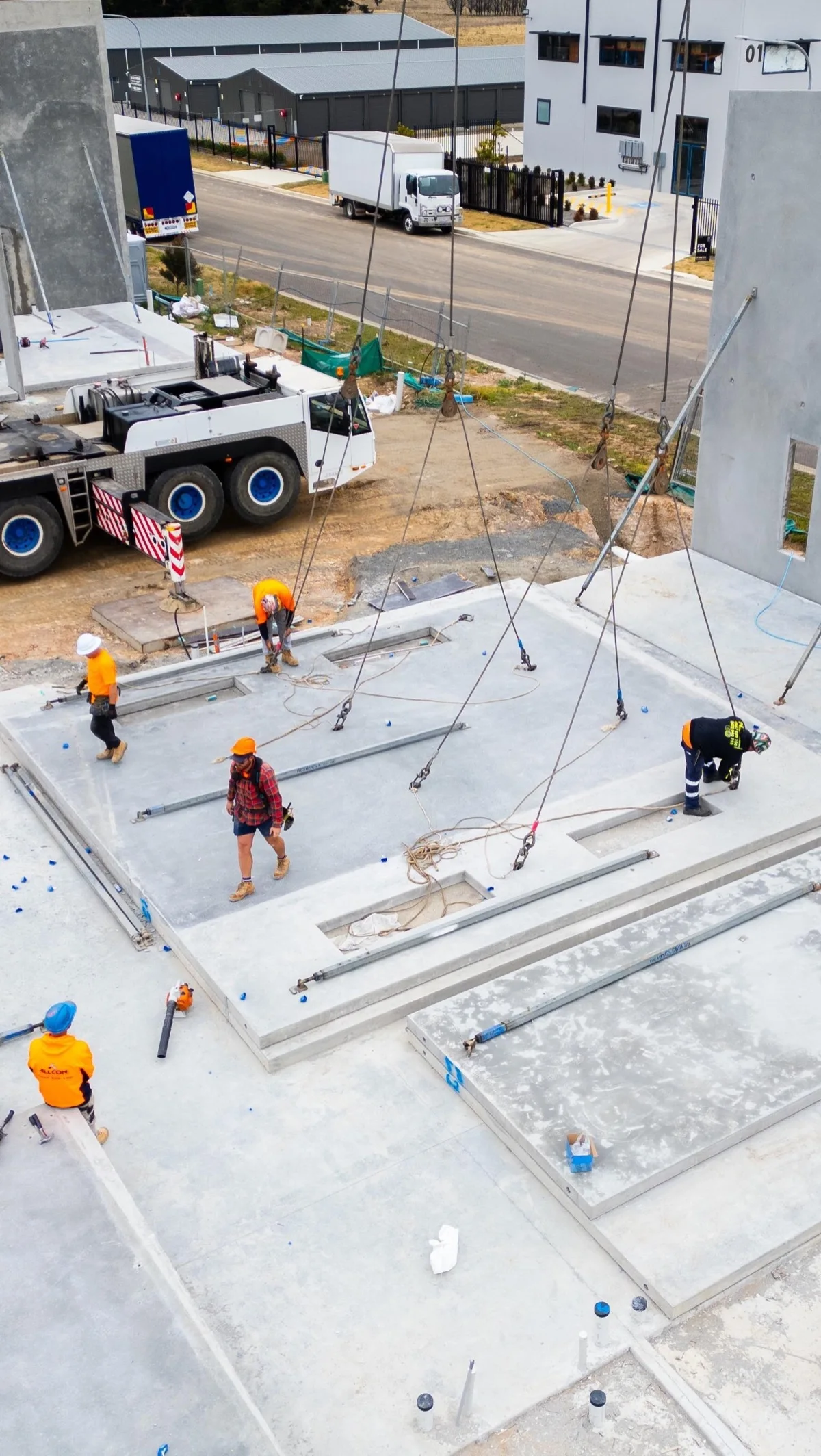 Workers and crane rigging on an active precast construction site