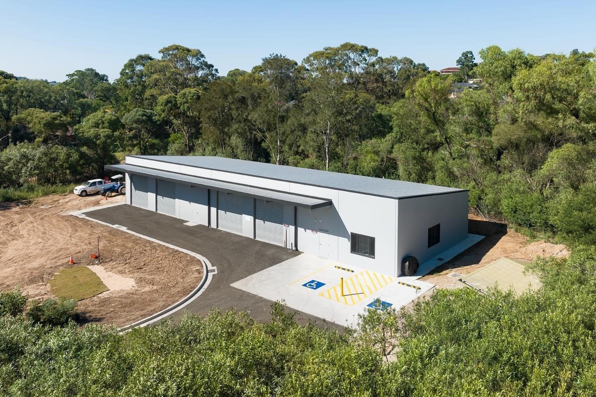 Aerial view of a completed utility building surrounded by trees